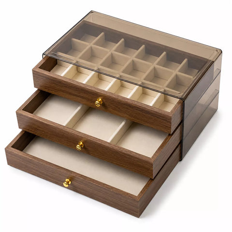 A three-tier wooden jewelry organizer box with a clear acrylic lid, featuring multiple compartments and three pull-out drawers with gold-tone knobs on a white background.