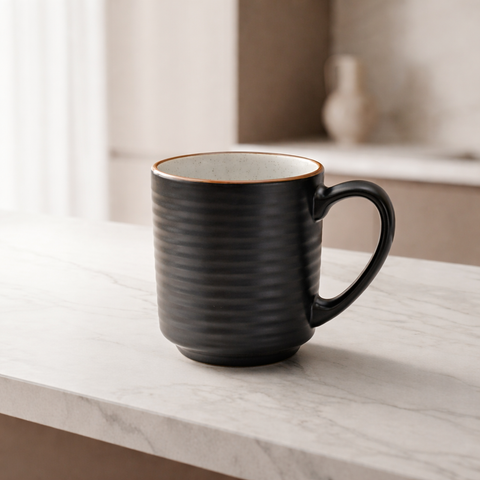 Black ceramic mug on a marble surface with a neutral background