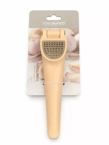 A beige garlic press tool attached to a printed retail card, photographed on a plain white background. The card shows the brand name Casosunco and includes garlic imagery.