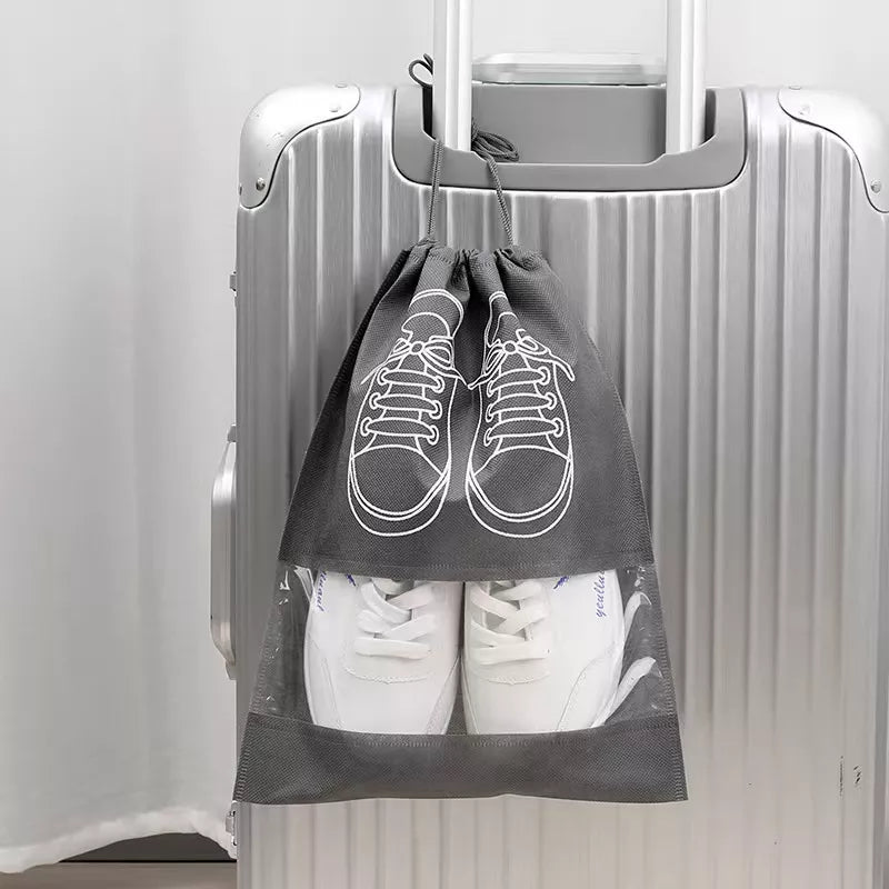 shoe bag with white shoes inside, attached to a suitcase against a white background