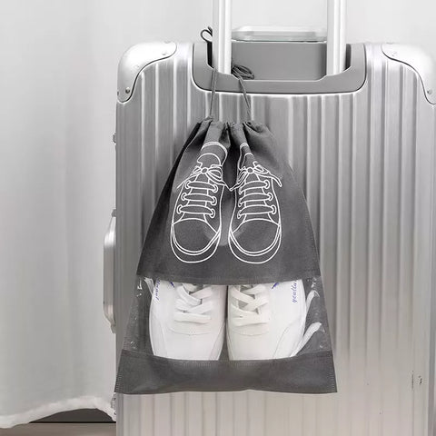 shoe bag with white shoes inside, attached to a suitcase against a white background