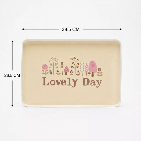 A rectangular beige tray with rounded corners, featuring a cute illustration of flowers, trees, a bird, and the words 'Lovely Day' in brown. Black dimension lines with text indicate a width of 38.