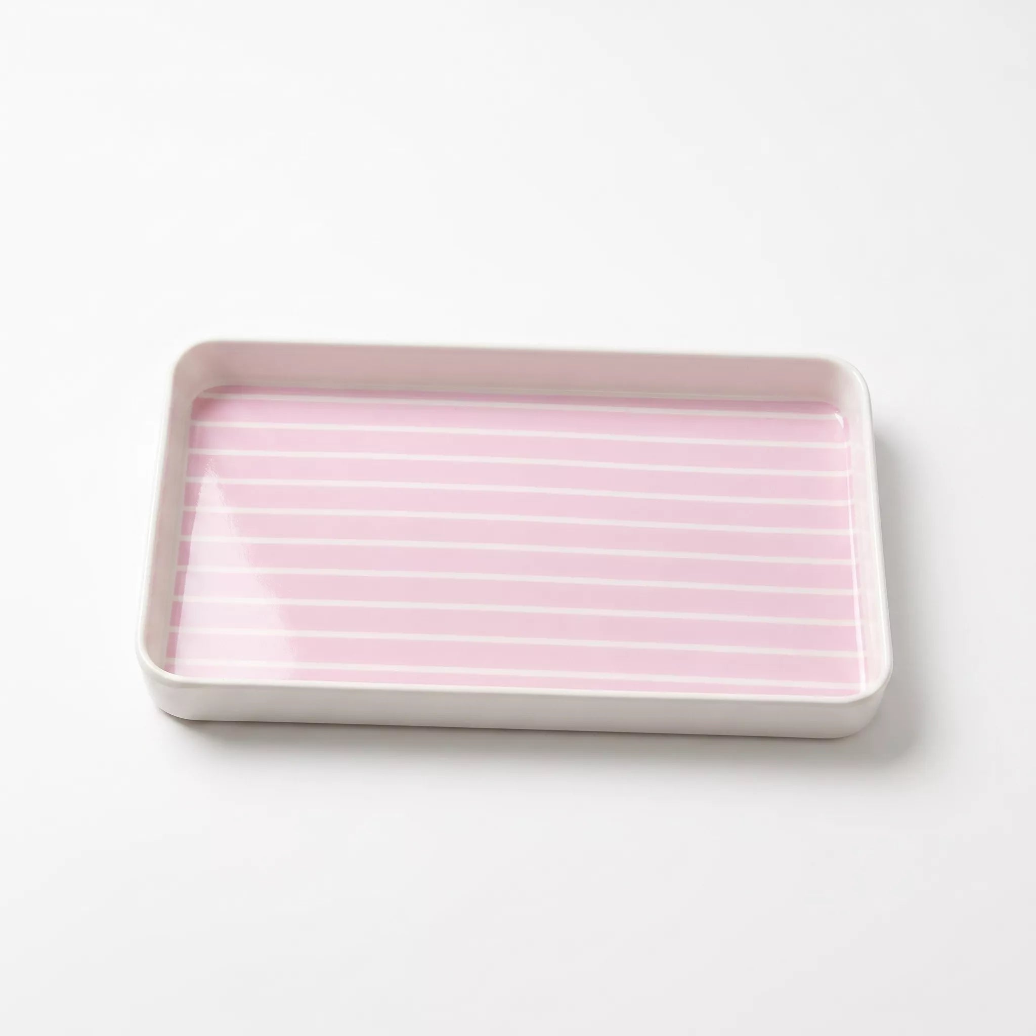 A rectangular shallow tray with a pale pink interior featuring thin white horizontal stripes, set against a clean white background.