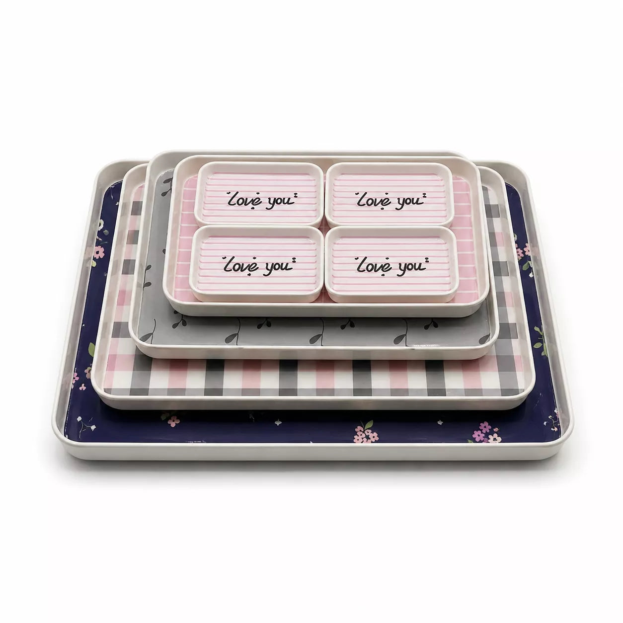 A set of nested square trays with decorative patterns, including a navy blue floral tray, a pink and gray checkered tray, a gray tray, and a white tray with four compartments printed with 'Love you' in script.